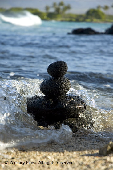 Morning, Kohala Coast, Hawaii. Lava stones and wave. The tide is going out, but the surf is rising. While making this stack at the spot reached by the last wave, I ask myself, “will these stones stay dry since the tide is going out, or will the rising surf overcome the tide and engulf the stones?” 2005.
