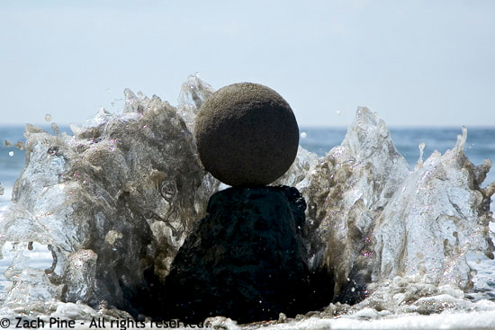 Afternoon, Muir Beach, California. Sand globe perched on a rock as the tide comes in. This wave spares the globe but gets me wet. 2007.