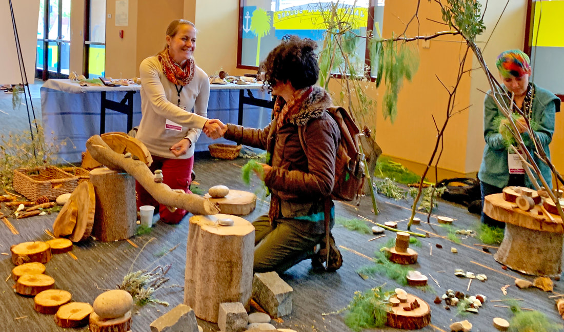 Two people shaking hands within an indoor Create-with-Nature zone