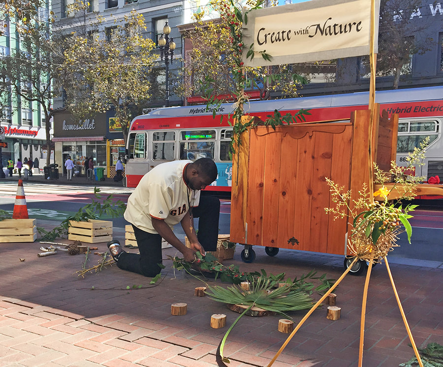 A man creates with nature on the sidewalk in downtown San Francisco