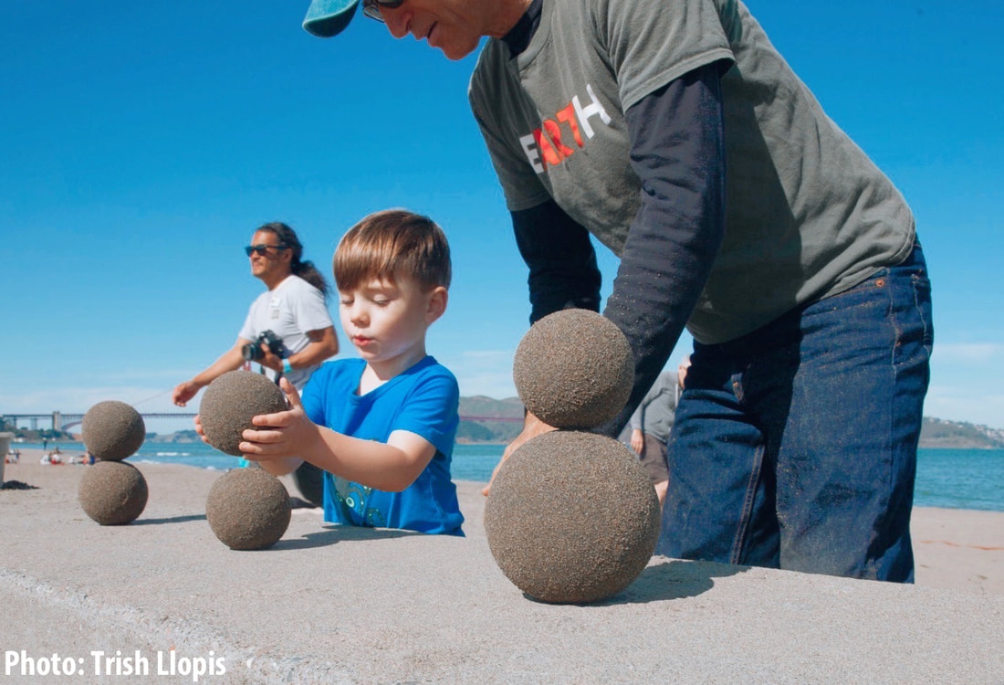 Child making sculpture from sand globes